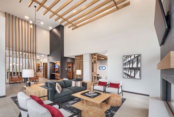 A modern living room with a wooden ceiling and a green couch.